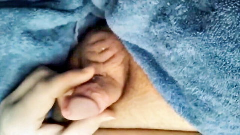 Amateur handjob on small penis, balls visible under blanket