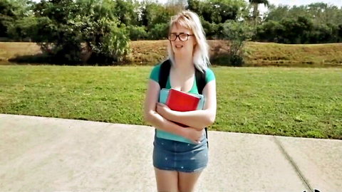 Nerdy white blonde cutie in glasses and short skirt outdoors