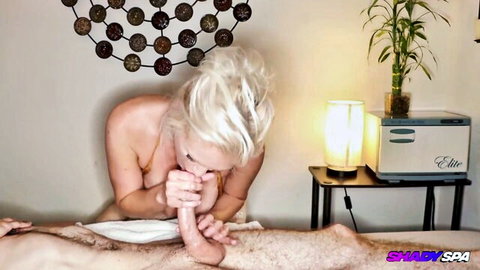 Topless blonde MILF with huge fake tits sucks client's toes in erotic massage room