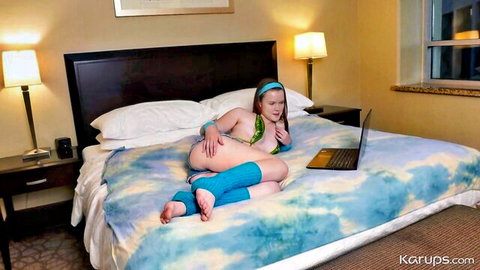 Ava Marina topless in blue leg warmers on bed with laptop