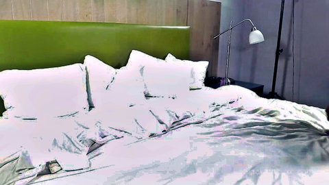 Messy rumpled white sheets and pillows on green headboard bed after wild fuck