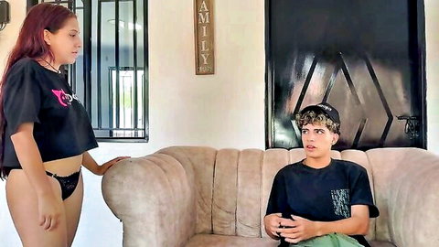 Latina teen in black thong panties teases stepbrother sitting on couch in family room
