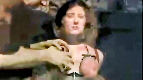 Bound submissive woman's huge tits squeezed hard by large gloved hands in domination