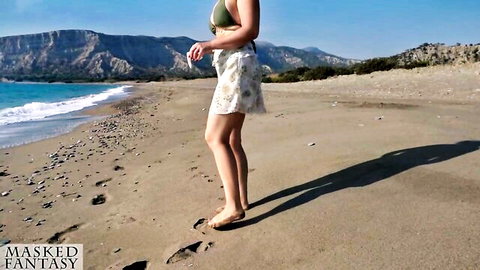 Fit woman in bikini top and short skirt posing on sunny beach