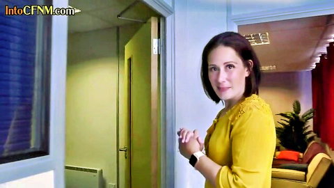Brunette woman in yellow blouse smiling in CFNM group handjob scene