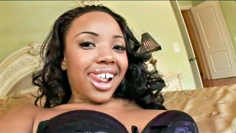 Ebony beauty with big tits and pierced tongue out teasing in black bra on bed