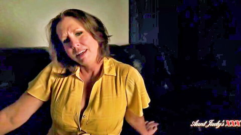 Aunt Judy MILF teases big tits cleavage in open yellow blouse on couch