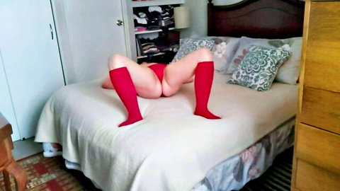 Mature slut in red stockings spreads legs exposing pussy on bed