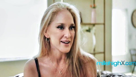 Blonde MILF in black tank top, seductive smile for stepson fantasy