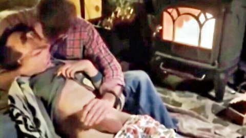 Passionate embrace between mature woman and young man in cozy setting
