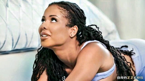 Kira Noir seductive gaze in white top, dreadlocks cascading
