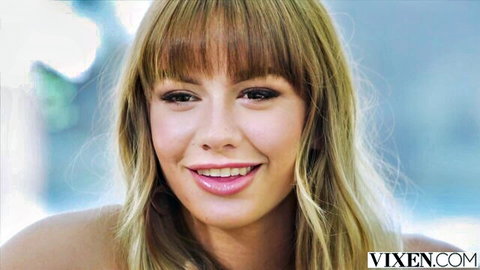 Naomi Swann smiles seductively with blonde bangs in Vixen tease
