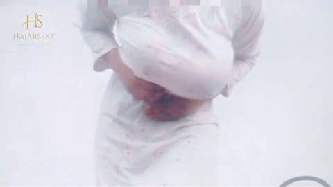 Arab woman in sheer white nightgown posing intimately
