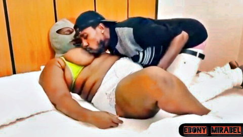 Ebony BBW in yellow bikini embraced and kissed by masked man from behind