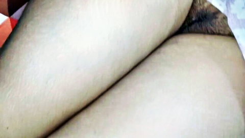 Close-up of mature woman's thighs and pubic area while resting in light dress