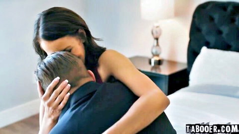 Brunette woman in red dress hugs man intimately from behind