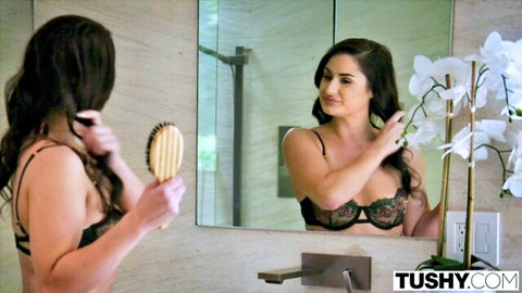 Kymberlie Rose in black lace lingerie brushing long hair in mirror