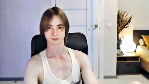 Slim young man with long brown hair in white tank top, solo webcam pose