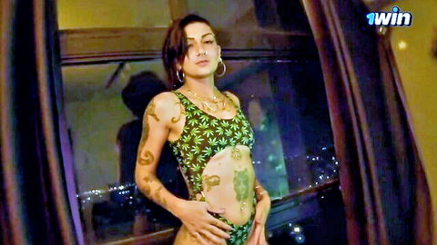 Tattooed Caroleta in sexy green cannabis leaf cut-out bodysuit