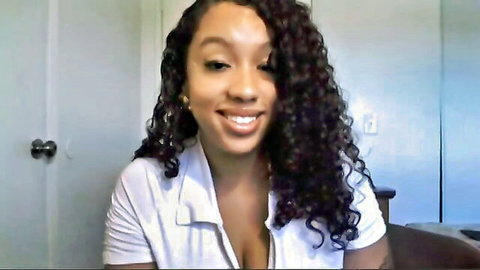 Smiling ebony babe with huge tits spilling from unbuttoned white shirt