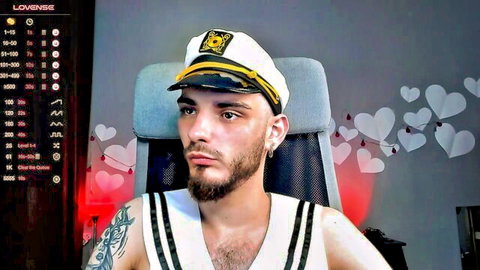 Bearded gay hunk in sailor captain hat and tight tank top posing on live webcam