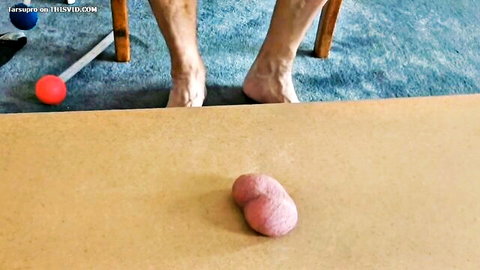 Mature bare feet near pink ball props on board game setup