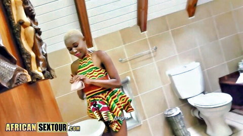 Short-haired African woman in colorful dress teasing in bathroom