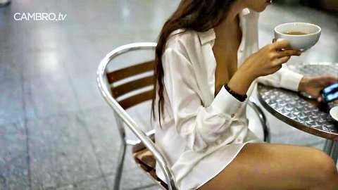 Alissa in thin white blouse with nothing underneath, showing deep cleavage while sipping tea
