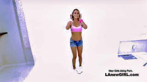 Blonde girl in pink bralette and denim shorts posing at porn audition