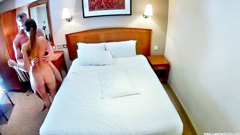 Naked amateur couple in doggy position on hotel bed with man gripping woman's bare ass and pussy from behind