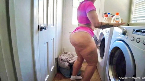 Curvy white woman in pink shorts showing big ass in laundry tease