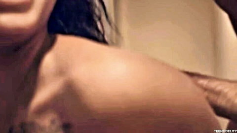 Brunette with ecstatic open-mouth expression as man's hand grips her bare shoulder closeup