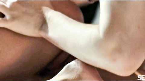 Pale beauty's hand caresses tanned hunk's muscular body in sensual nude embrace