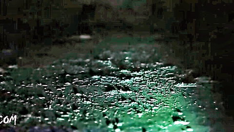 Mysterious rainy BDSM scene with glowing green water droplets