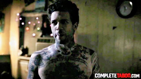 Tattooed muscular man with intense gaze in taboo adult scene