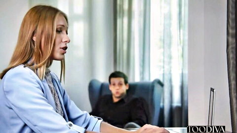 Angelika Grays in blue blazer at laptop with man in office
