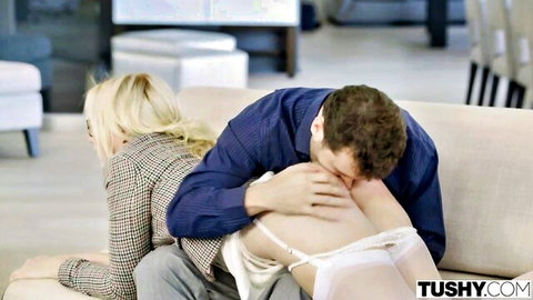 Blonde babe in garter stockings bent over couch as man kisses her bare ass