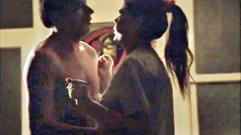 Topless muscular black man intimately embraces busty brunette ponytail woman