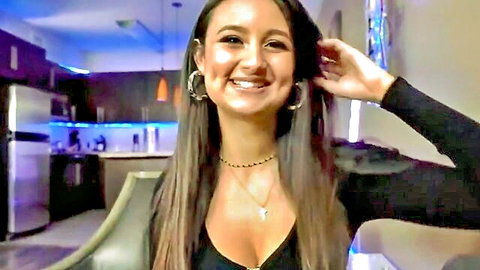Eliza Ibarra, stunning Latina with long dark hair, smiling in low-cut black top showing cleavage