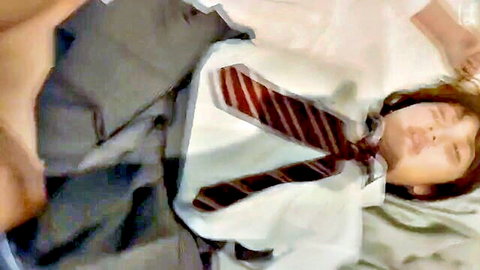 Asian schoolgirl in white shirt and red tie lying on bed