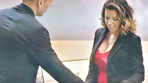 Danica Dillon in sexy red top and blazer shaking hands with suited man