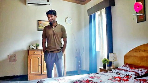 Handsome Indian man in green shirt and gray pants standing confidently
