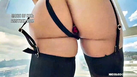 Big booty woman in black stockings and garter belt with red anal plug visible