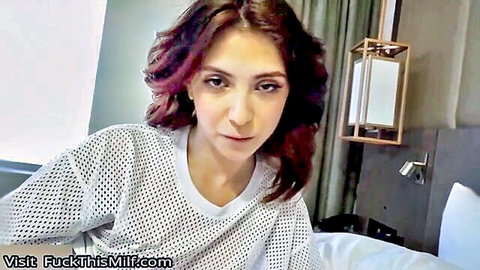 Brunette stepsis in see-through mesh top on bed, seductive gaze