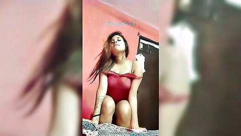 Young Indian babe in red lingerie slips strap teasing perky tits on bed