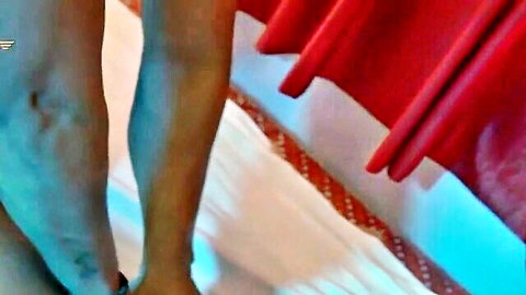 South Asian mature woman's veiny thighs spread wide on massage bed with red curtains
