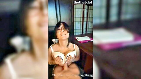 Bigtittygothegg smiling while holding her massive overflowing tits in white lace bra
