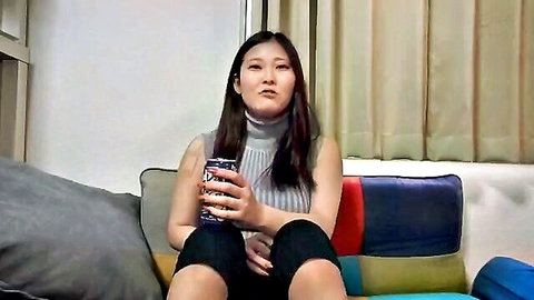 Asian woman in turtleneck sweater relaxing solo on couch