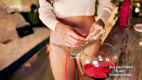 Effylowell tattooed camgirl in white crop top and thong holding raffle tickets