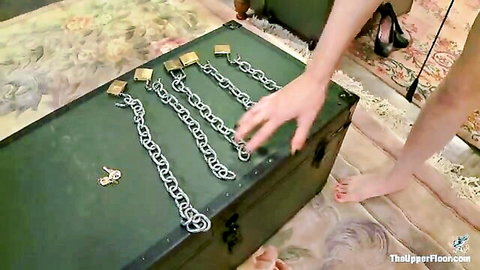 Femdom hand grabbing heavy chains and padlocks from BDSM slave chest